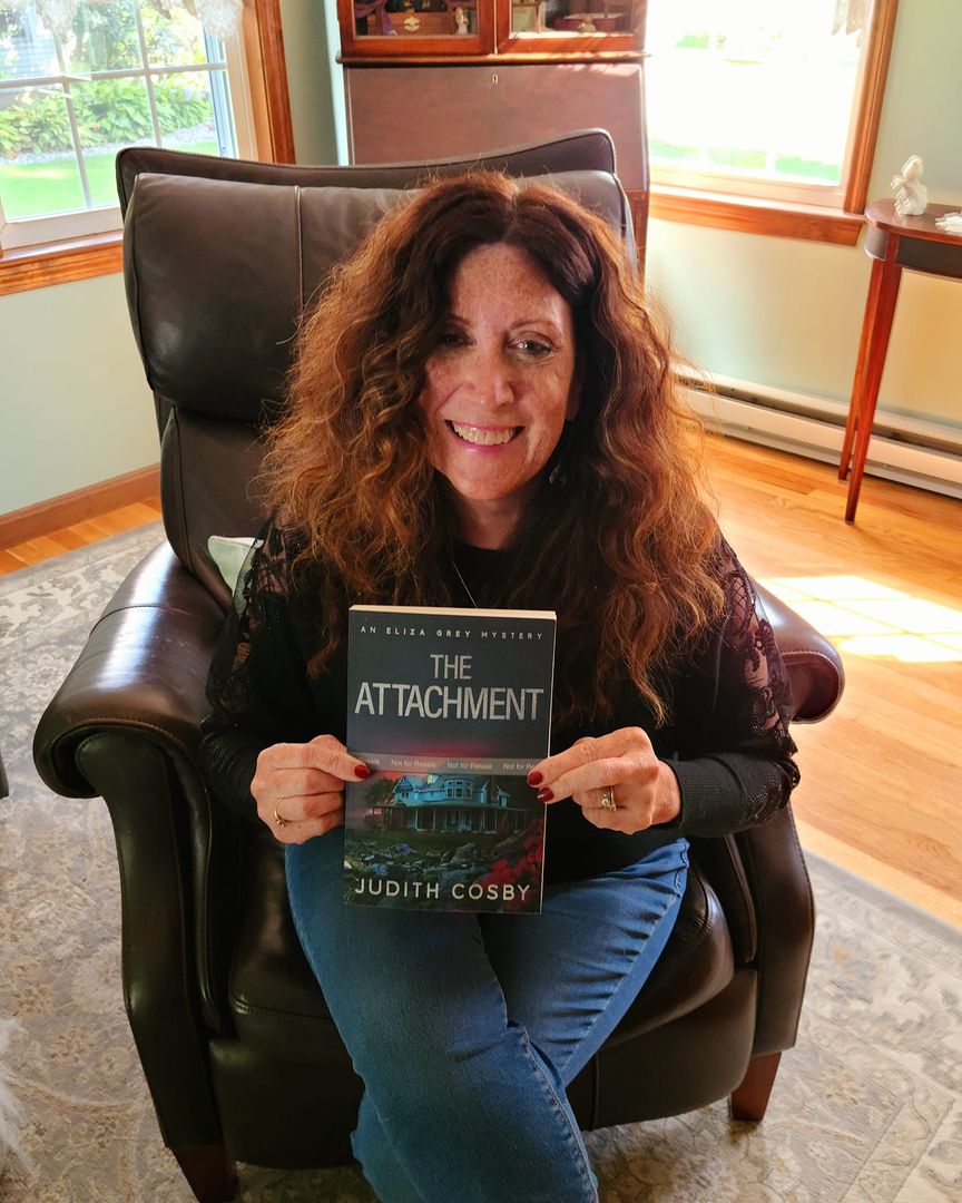 author Judith Cosby holding a copy of her book The Attachment